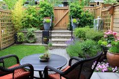 an outdoor patio with chairs, table and potted plants