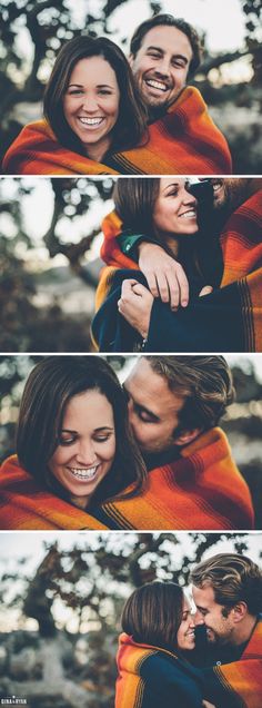 two people hugging each other while wrapped in a blanket and smiling at the camera with trees in the background