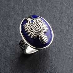 an image of a ring with blue glass and silver accents on the front, sitting on a