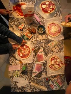 several people are making pizzas at a table