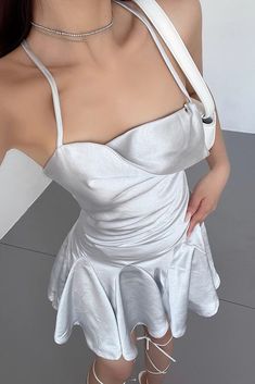 a woman wearing a white dress and choker posing for the camera with her hands on her hips