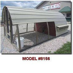 a large metal chicken coop sitting on top of gravel next to a building with a sign that says model 816