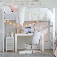 a white loft bed with lights strung from the ceiling and desk in front of it