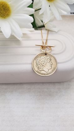 This authentic and vintage Greek coin makes a fabulous gold medallion necklace. It is a   100 or 50 drachma coin set on an 18" gold-plated chain. Your choice of a front toggle closure or a back lobster clasp with a 3" chain extender. The coin has been polished and matches the chain beautifully. Welcome to Recycled Finery!  I repurpose old jewelry, coins, beads, vintage buttons, watch parts, and charms into new jewelry.  My ever-growing collection of these materials comes from estate sales, rumma Nickel-free Yellow Gold Medallion Coin Necklace, Medallion Coin Necklace With Vintage Charm As A Gift, Vintage Medallion Coin Necklace As A Gift, Vintage Charm Medallion Coin Necklace As Gift, Vintage Charm Medallion Coin Necklace For Gift, Vintage Charm Coin Necklace With Round Pendant As Gift, Gold Coin Necklace Nickel Free, Antique Gold Coin Necklace Nickel Free, Classic Tarnish Resistant Coin Necklace For Gift