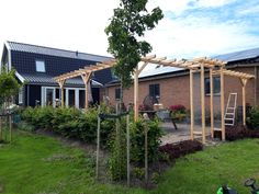 a house with an attached pergolated patio and garden area