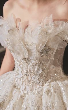 the back of a wedding dress with white flowers on it's waist and shoulders