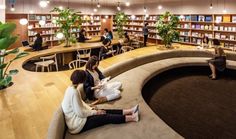 two women sitting on the floor in front of a circular table with bookshelves