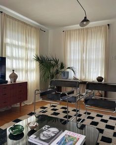 a living room filled with furniture and a flat screen tv on top of a wooden table