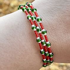 a close up of a person's arm wearing two bracelets with green and white beads