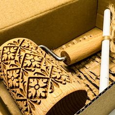 an open box with a wooden carving in it and two candles inside the box next to it