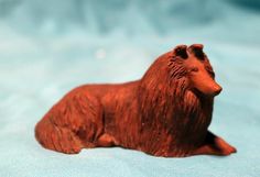 a brown bear figurine laying on top of a blue sheet