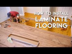 a man is installing laminate flooring in the middle of a room with wood floors