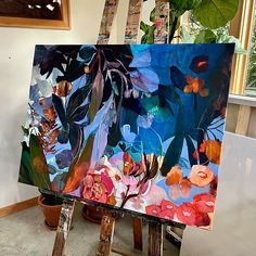 an easel with some paintings on it in the process of being painted by someone