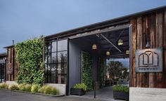 an entrance to a restaurant with plants growing on the wall and doors that are open