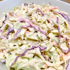 a white plate topped with a salad covered in coleslaw and red onion dressing