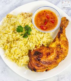 a white plate topped with rice and chicken next to a bowl of tomato relish