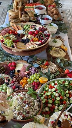 a table filled with lots of different types of food on plates and serving trays