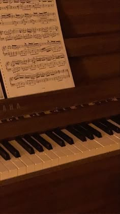 an old piano with sheet music on it's keys and notes attached to the organ