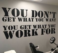 a gym wall with the words you don't get what you want, you get what you work for