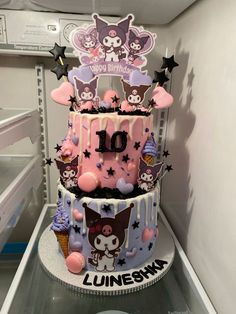 a three tiered cake decorated with pink and purple icing