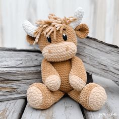 a crocheted stuffed animal sitting on top of a wooden table