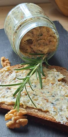 a jar filled with food sitting on top of a piece of bread next to crackers