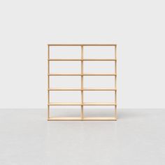 an empty wooden shelf sitting on top of a white floor