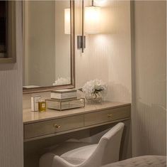 a desk with a mirror, chair and lamp in a hotel room at night time