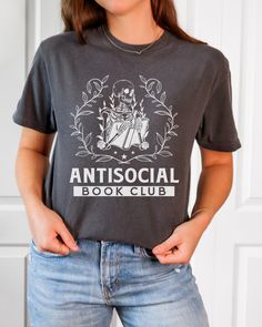 Looking for the perfect gift for a book-loving friend or family member? Look no further than this Comfort Colors T-shirt for the Anti-Social Book Club. With its stylish design and comfortable fit, this shirt is sure to be a hit with any bookworm or booktrovert. Screen Print Short Sleeve Tops, Literary Style Short Sleeve Screen Print Tops, Bookish Crew Neck T-shirt With Letter Print, Literary Black Cotton T-shirt, Black Literary Crew Neck T-shirt, Relaxed Fit Pre-shrunk Bookish T-shirt, Literary Cotton T-shirt With Text Print, Bookish T-shirt With Letter Print And Crew Neck, Black Bookish T-shirt With Screen Print