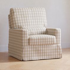 a chair with a checkered pattern on the back and arms, in front of a white wall