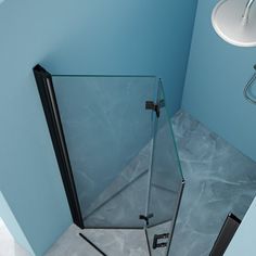 the corner of a bathroom with a glass shower door and blue walls is seen from above