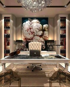 an office with a desk, chandelier and large floral painting on the wall