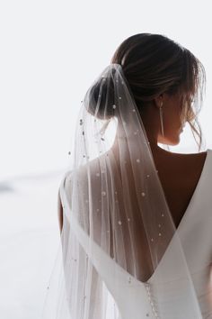 a woman wearing a wedding veil and earrings