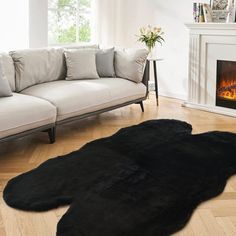 a living room filled with furniture and a fire place next to a couch on top of a hard wood floor