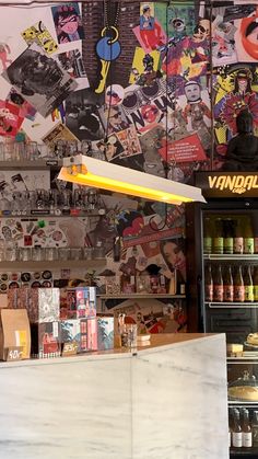 the inside of a store with various items on shelves and posters above it, along with an ice cream display