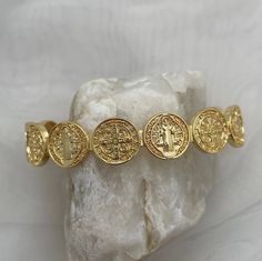 Gorgeously unique, this stunning medal coin cuff bracelet is perfect for wearing alone or stack with some of our gold fill bead bracelets. The Benedictine Medal is one of the most powerful symbols of divine protection. Wear this petite bracelet as a reminder that you are protected by God's army and as St Benedict did, to do good every day.  Tradition holds that it stands for the power of prayer in times of temptation and suffering, wards against evil, and symbolizes how prayer creates peace within ourselves and in our communities. Specifications - Adjustable cuff, one size fits most, up to wrist size 7.5 18kt gold plated or sterling silver plated Cheap Symbolic Bracelets, Luxury Gold Medallion Bracelets, Cheap Gold Spiritual Bracelets, Vintage Gold Plated Bracelets, Spiritual Jewelry Gold, Gold Antique Bracelet, God's Army, Czech Beads Jewelry, Keep Bracelet