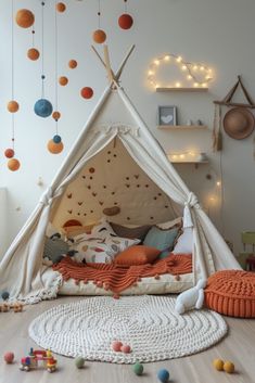 a child's teepee with balls hanging from the ceiling and on the floor