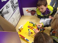 two children are playing with legos on the floor