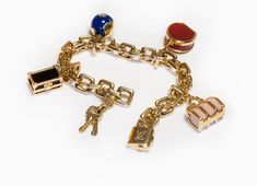 Louis Vuitton Gold Charm Bracelet.Chain bracelet with padlock, globe and luggage charms crafted in 18K yellow gold by Louis Vuitton from 2000 Collection. Semi-precious stones, carnelian, onyx, white coral and blue enamel. Bracelet will fit up to a 7.5 inches wrist. Weight 150 Grams. This Louis Vuitton bracelet is highly collectable! Padlock keys and charms with LV monogram and French hallmarks which are stamped on most of its products, like watches, jewelry, accessories etc. Louis Vuitton is one Luxury Charm Bracelet With Logo, Luxury Charm Bracelet With Logo Charm As Gift, Luxury Logo Charm Bracelet As Gift, Luxury Gold-tone Jewelry As A Gift, Luxury Chain Charm Bracelet For Formal Occasions, Luxury Yellow Gold Charm Bracelet With Logo, Luxury Formal Bracelets With Charms, Luxury Lock Jewelry For Gift, Luxury Chain Charm Bracelet For Gift