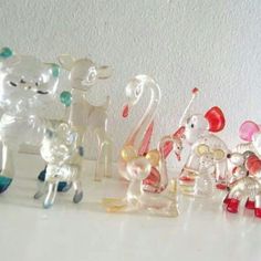 small glass figurines are lined up on a table