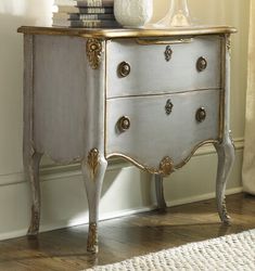 a white and gold chest of drawers in a room