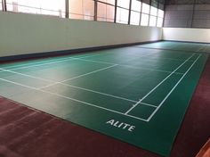 an indoor tennis court with the name alite on it's floor and windows