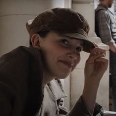 a woman sitting at a table with a hat on her head