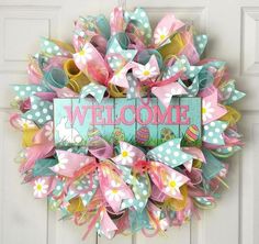 a welcome spring wreath on the front door with flowers and polka dot ribbon around it