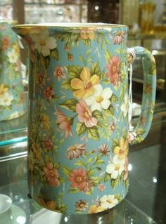 a blue floral mug sitting on top of a glass table