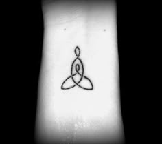 a black and white photo of a wrist tattoo with an image of a symbol on it