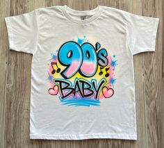 a white shirt with the words 90's baby painted on it