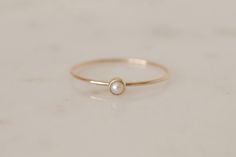 ELLA 14K Gold Pearl Ring - a gorgeous everyday piece. For a simple and feminine look, wear it just by itself or stack it up with our BELLA Simple Band or LIV Twisted Band Stacking Rings. Materials - 14k recycled solid gold, quality marked - approx. 0.8mm band width - smooth and shiny texture - 3mm Pearl size, round cut cabochon Freshwater Pearl, cultured - never wild caught. Only the prettiest pearls are handpicked for your jewelry. As natural products they may slightly differ in color and shape Pearl Rings In Gold, Pearl Stacking Ring, Rings In Gold, Pearl Rings, Gold Pearl Ring, Twisted Band, Right Hand Rings, Local Jewelry, Solid Gold Rings