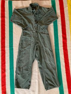 "Vintage 70s/80s military coveralls. OG 107 cotton sateen. Made in USA. In good vintage condition. Has some holes and stains throughout, tried to show in photos. Lots of cool mending. If you don't liked the trashed look then these are not for you. Great fade and patina. Adjustable at the waist and ankles. Tags missing. Size marked with a marker, \"M\" but please refer to the actual measurements: 23 inches from pit to pit measured lying flat, 18 inches across the shoulders, 17 inches across the w Vintage Jumpsuits And Rompers For Fall, Military Style Cotton Overalls, Military Style Long Sleeve Cotton Jumpsuit, Military Style Long Sleeve Cotton Jumpsuits And Rompers, Vintage Washed Cotton Overalls, Vintage Long Sleeve Jumpsuits And Rompers For Fall, Vintage Green Cotton Jumpsuits And Rompers, Coverall Men, Mechanic Jumpsuit