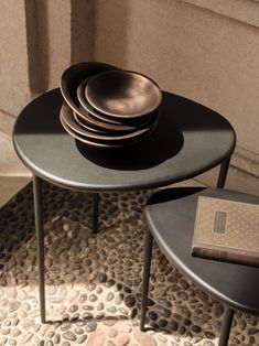 a stack of plates sitting on top of a black table next to a brown book